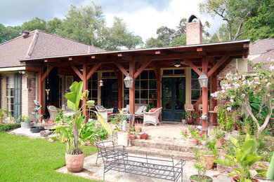 Ispirazione per un patio o portico tradizionale dietro casa e di medie dimensioni con pavimentazioni in mattoni e un tetto a sbalzo