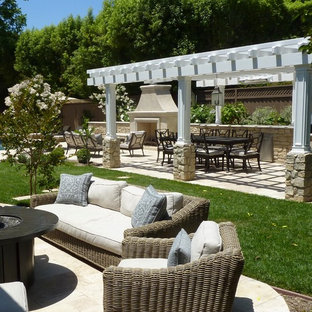 Immagine di un grande patio o portico tradizionale dietro casa con un focolare e pavimentazioni in pietra naturale