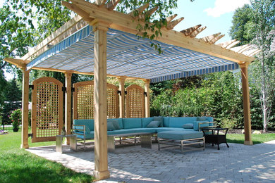 Design ideas for a traditional back patio in Toronto with a pergola.