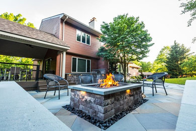 Inspiration for a large traditional back patio in Philadelphia with a fire feature, natural stone paving and a gazebo.