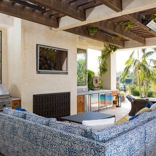 Foto di un patio o portico mediterraneo con piastrelle e una pergola