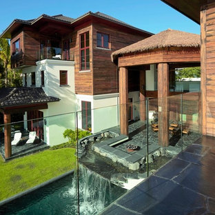 Foto di un ampio patio o portico etnico dietro casa con fontane, pavimentazioni in pietra naturale e un tetto a sbalzo