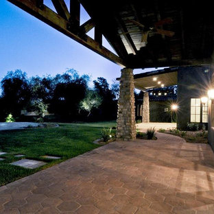 Immagine di un ampio patio o portico bohémian dietro casa con pavimentazioni in cemento e un tetto a sbalzo