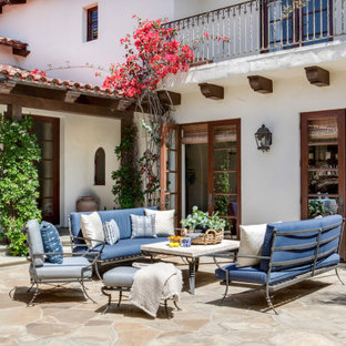 Ispirazione per un grande patio o portico mediterraneo in cortile con un caminetto, pavimentazioni in pietra naturale e nessuna copertura