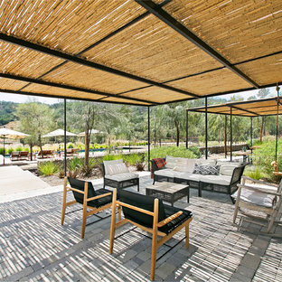 Idee per un patio o portico country dietro casa con pavimentazioni in cemento e una pergola