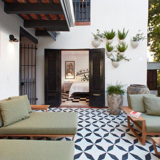 Example of a huge island style backyard tile patio fountain design in Other with no cover