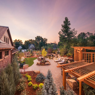 Idee per un grande patio o portico stile americano dietro casa con un focolare, pavimentazioni in cemento e una pergola