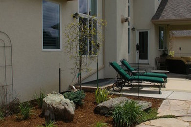 Modelo de patio tradicional grande en patio trasero y anexo de casas con cocina exterior y adoquines de piedra natural