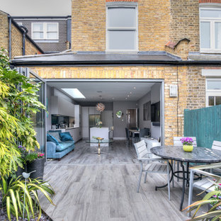 Inspiration for a medium sized contemporary back patio in London with a potted garden and no cover.