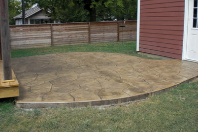 Inspiration for a mid-sized backyard stamped concrete patio remodel in Other with no cover