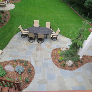 Idee per un patio o portico chic di medie dimensioni e dietro casa con un focolare, pavimentazioni in pietra naturale e un tetto a sbalzo