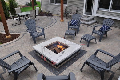 Inspiration for a large timeless backyard concrete paver patio remodel in Chicago with a fire pit and a pergola