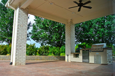 Ejemplo de patio grande en patio trasero y anexo de casas con cocina exterior y adoquines de hormigón