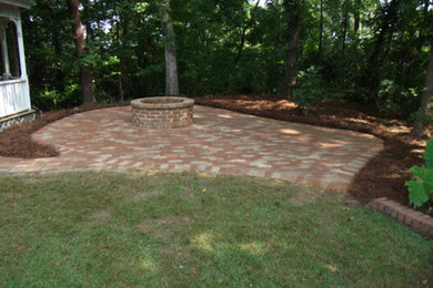 This is an example of a medium sized back patio in Birmingham with a fire feature and brick paving.
