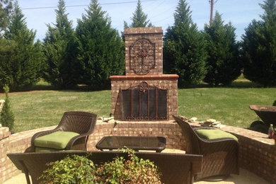 Large elegant backyard brick patio photo in Other with a fire pit and no cover