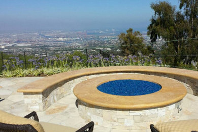 Inspiration for a mid-sized contemporary backyard stone patio remodel in Orange County with a fire pit and no cover