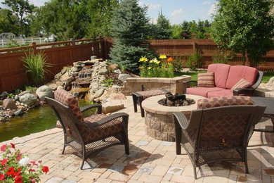 Foto de patio clásico grande sin cubierta en patio trasero con brasero y adoquines de ladrillo