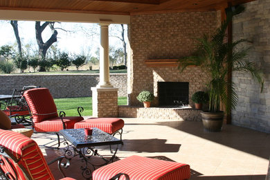 Mid-sized elegant backyard tile patio photo in Other with a fire pit and a roof extension
