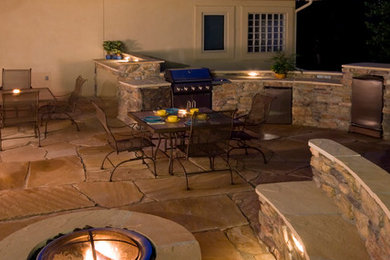 Backyard stone patio photo in Other with a fire pit and no cover