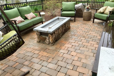 Example of a mid-sized classic backyard brick patio design in Boston with a fire pit and no cover