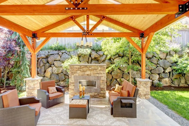 Example of a backyard concrete paver patio design in Cedar Rapids with a fire pit and a gazebo