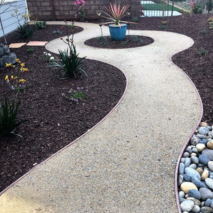 Foto di un grande patio o portico minimalista con un focolare e graniglia di granito