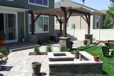 Example of a mid-sized classic backyard concrete paver patio design in Denver with a fire pit and a pergola