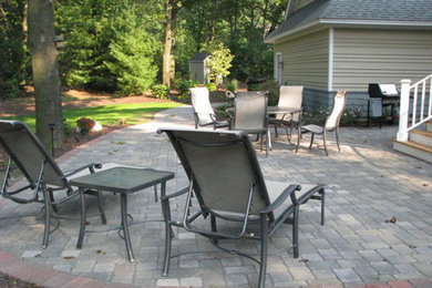 Modelo de patio clásico sin cubierta en patio trasero con adoquines de piedra natural