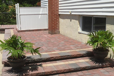 Modelo de patio tradicional de tamaño medio sin cubierta en patio trasero con adoquines de piedra natural
