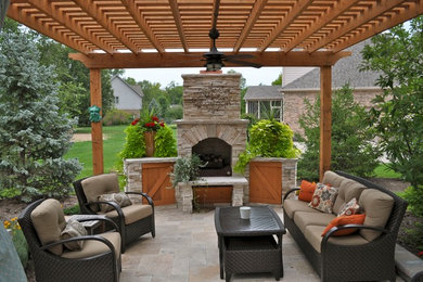 Diseño de patio clásico de tamaño medio en patio trasero con brasero, pérgola y adoquines de piedra natural