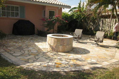 Imagen de patio grande sin cubierta en patio trasero con brasero y adoquines de piedra natural
