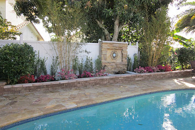 Diseño de patio grande sin cubierta en patio trasero con brasero y adoquines de piedra natural