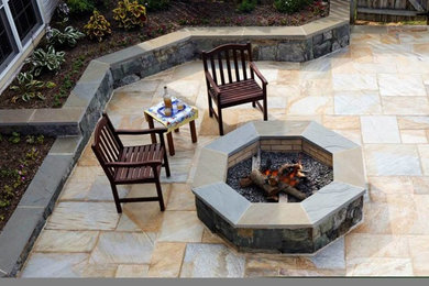 Example of a large classic backyard stone patio design in DC Metro with no cover
