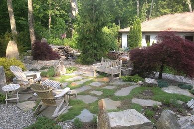 This is an example of a medium sized contemporary back patio in Bridgeport with natural stone paving and no cover.
