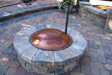 Patio - mid-sized backyard stone patio idea in Other with a fire pit and no cover