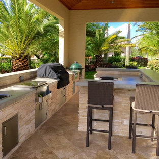 Ispirazione per un grande patio o portico tropicale dietro casa con pavimentazioni in pietra naturale e un gazebo o capanno