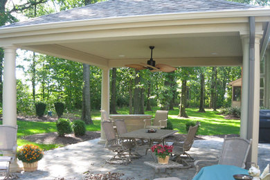 Modelo de patio tradicional grande en patio trasero con adoquines de piedra natural y cenador