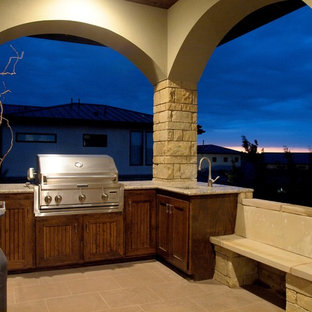 Esempio di un patio o portico american style di medie dimensioni e dietro casa con piastrelle e un tetto a sbalzo