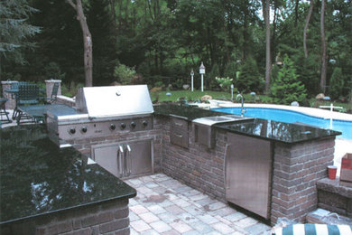 Example of a backyard brick patio design in New York with a fire pit
