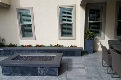 Cette photo montre une terrasse arrière tendance avec du carrelage et une extension de toiture.
