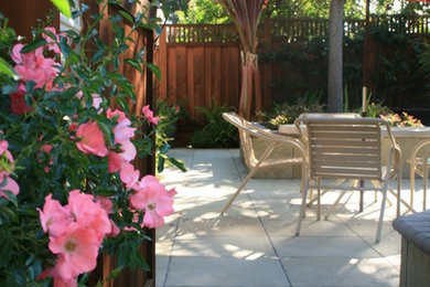 Ejemplo de patio clásico sin cubierta en patio trasero con adoquines de hormigón