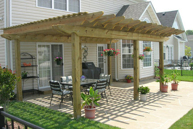 Example of a mid-sized classic backyard stamped concrete patio vertical garden design in Other with a pergola