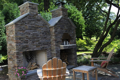Example of a mid-sized arts and crafts backyard stone patio kitchen design in New York with a roof extension