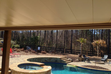Example of a backyard concrete patio container garden design in Atlanta with a roof extension