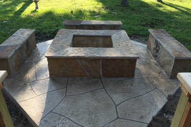 Example of a mid-sized classic backyard stone patio design in Houston with a fire pit and no cover