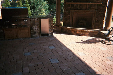 Patio kitchen - mid-sized backyard stone patio kitchen idea in Atlanta with a roof extension