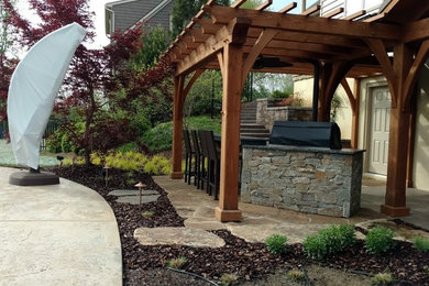Inspiration for a medium sized classic back patio in Other with an outdoor kitchen, natural stone paving and a pergola.