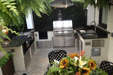 Example of a large backyard brick patio kitchen design in Charleston