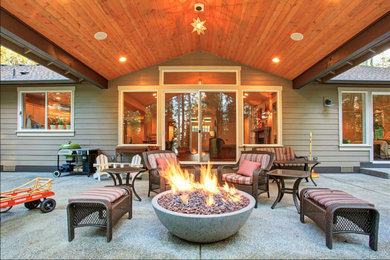 Large trendy backyard patio photo in Los Angeles with a fire pit and a roof extension