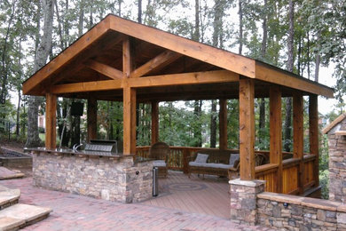 Large arts and crafts backyard stone patio kitchen photo in Atlanta with a pergola